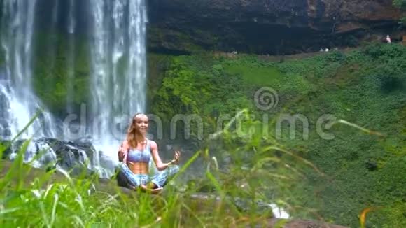 美丽的女孩在大瀑布和悬崖上冥想视频的预览图