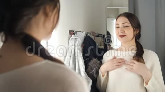 在试衣间照镜子的时髦女孩视频的预览图