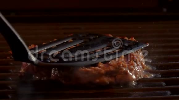 厨房抹刀将汉堡压到热烤架上视频的预览图