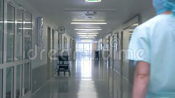在诊所大厅里散步的人穿着医生制服的人在医院大楼里散步视频的预览图