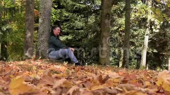 秋公园里坐着一个深褐色头发的女人视频的预览图