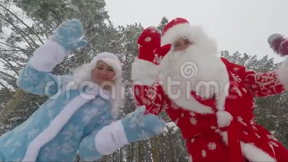 圣诞老人和孙女在森林里的摄像机上挥手慢动作视频视频的预览图