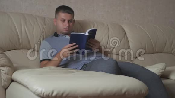 年轻人在家坐在沙发上看书视频的预览图