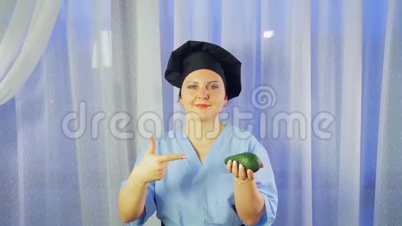 一位女厨师微笑着手里拿着一个鳄梨指着它视频的预览图
