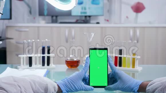科学家持有一个带有隔离绿色屏幕模型的智能手机视频的预览图