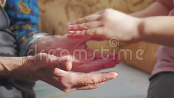 孩子的手和年长女人的手一个孩子正在拥抱祖母手视频的预览图