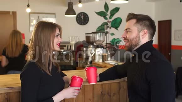 一对夫妇坐在一家咖啡店里喝着红杯咖啡视频的预览图