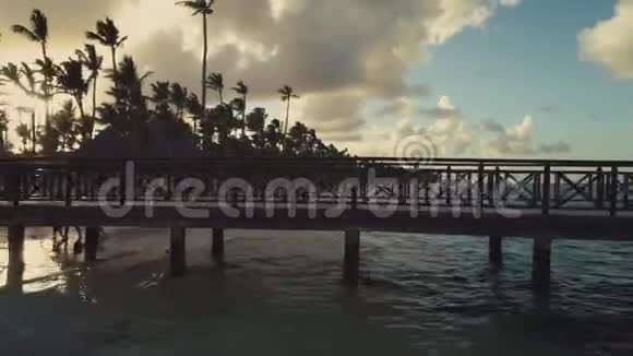 木墩急流在泻湖上的钻孔镜头海滩上的手掌和多云的天空背景晚上日落巴瓦罗视频的预览图