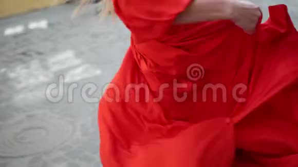 穿着精致红色裙子的女孩在街边镜头前摆姿势慢镜头视频的预览图