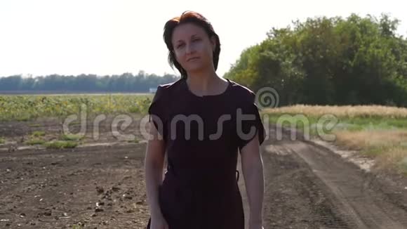 一个女农民慢慢地走在犁地上在田野上检查庄稼一个穿着一件衣服的疲惫的女孩穿着一件性感的衣服视频的预览图
