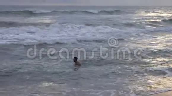 日落时分年轻人在热带海洋中游泳视频的预览图
