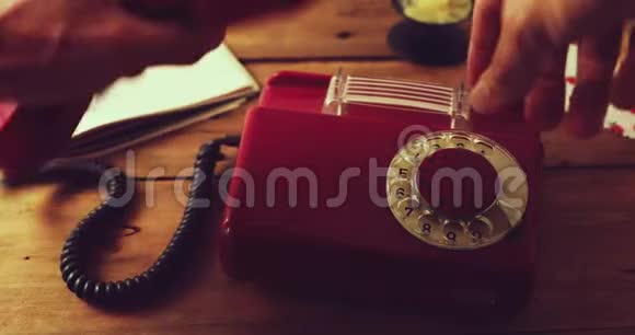 在旧的复古旋转电话上用手拨号码视频的预览图