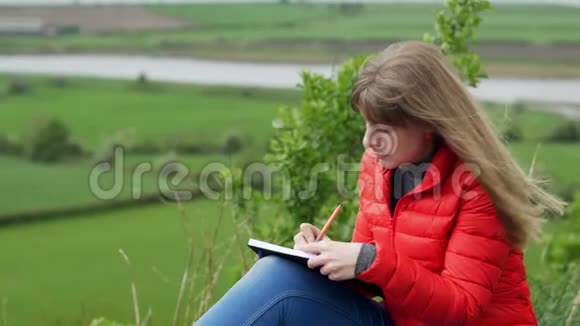 女孩坐在公园里写日记视频的预览图