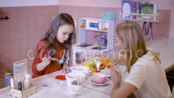 我们玩吧有意识的小女孩一边给妈妈喂奶一边在咖啡馆里消磨时间视频的预览图