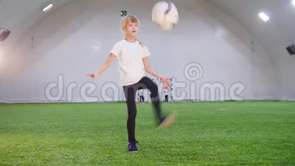 室内足球场一个玩球的小女孩把它扔上去然后用腿打视频的预览图