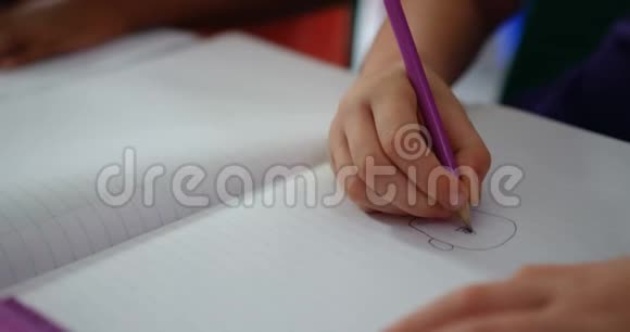 4k教室笔记本上学生绘画特写视频的预览图