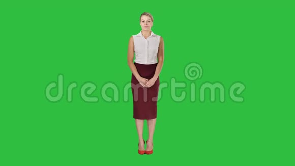 年轻女子穿着正式的紧身衣看着相机手臂折叠在绿色屏幕上Chroma键视频的预览图