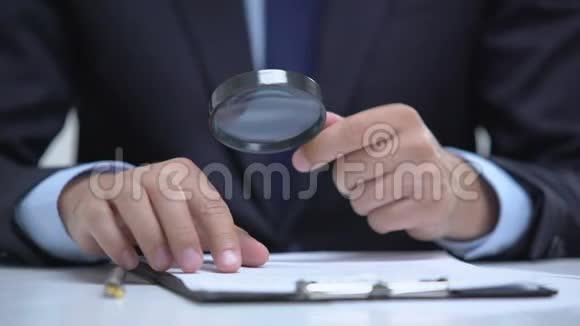 律师用放大镜阅读文件详细研究案件调查视频的预览图