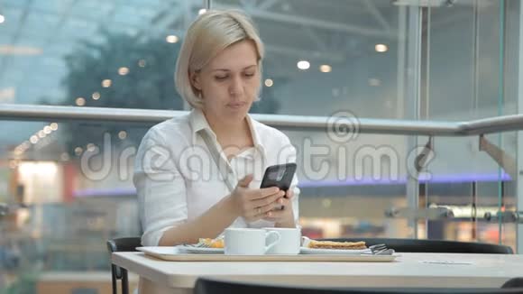 一个女人在餐馆吃饭在社交网络的智能手机上写字视频的预览图