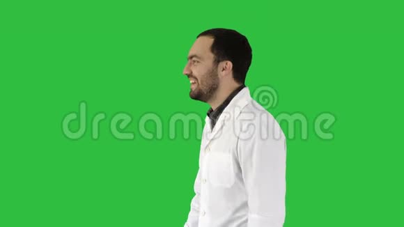 微笑的建筑工程师抓住一个帽子并把它放在一个绿色的屏幕色度键视频的预览图