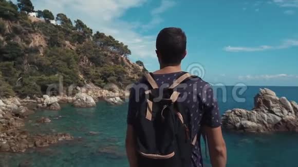 男性游客在夏季海岸欣赏海景和玄武岩岩石视频的预览图