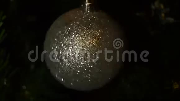 在黑暗的背景下旋转一个闪闪发光的圣诞球视频的预览图