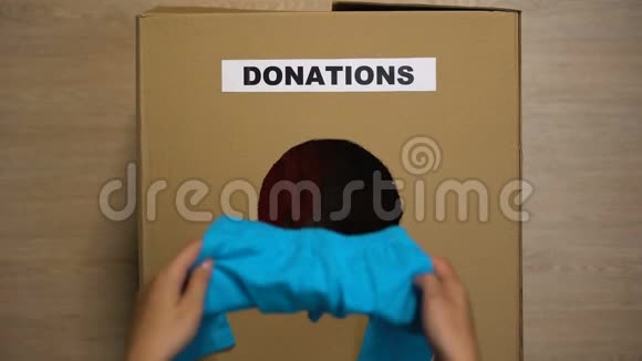 把旧衣服放在纸板箱里接受捐赠的女人视频的预览图