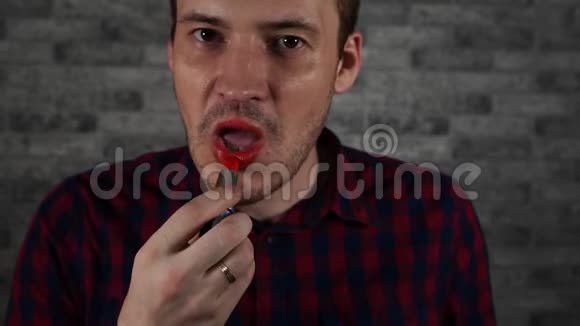 一个人用红色口红对着砖墙涂嘴唇视频的预览图
