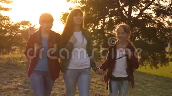 徒步旅行者女孩一家人在树林里散步女孩旅行穿过森林女孩带着背包在乡间小路上旅行视频的预览图