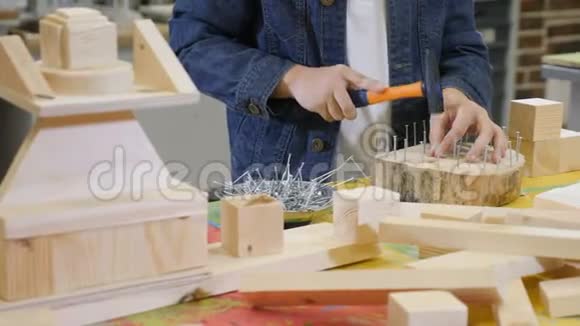 孩子们在工艺车间玩耍可爱的小男孩锤钉特写镜头帮他父亲打理房子的男孩视频的预览图