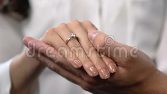 有爱心的男人用手指上的订婚戒指牵着女朋友的手结婚视频的预览图