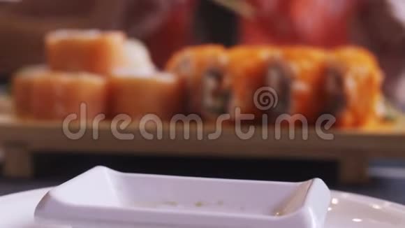 女性手把酱油从一个小盒子里倒入平底锅旁边是寿司视频的预览图