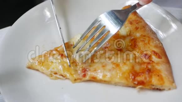 女人用刀叉切一块比萨饼美味的食物供暴食和享受快餐饮食概念视频的预览图