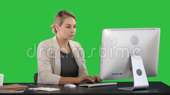 优雅快乐的女商人在电脑上工作的绿色屏幕铬钥匙视频的预览图