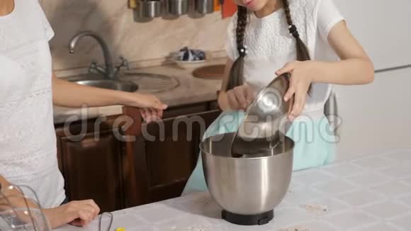 妈妈和女儿在家的厨房里一起做海绵蛋糕视频的预览图