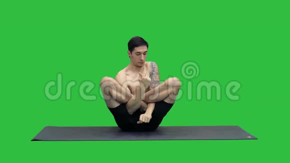 肌肉发达的年轻男子锻炼瑜伽莲花手在脸上的绿色屏幕Chroma键视频的预览图