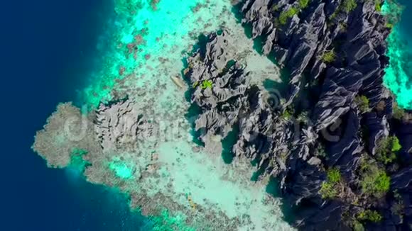 空中俯视飞行惊人的岩石和热带珊瑚礁泻湖独木舟正在海上航行布桑加冠视频的预览图