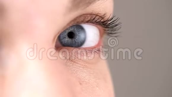 一个年轻女孩的蓝眼睛特写在镜头前盯着看视频的预览图