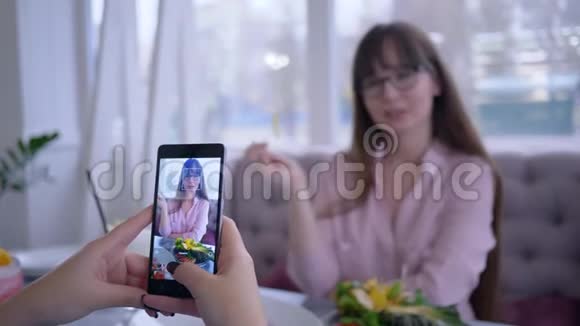适当的营养微笑的女孩戴着眼镜为女朋友摆着水果盘用手机拍照视频的预览图