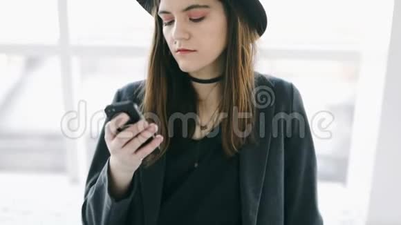 发短信聊天的年轻女孩在时尚的帽子休闲生活录像视频的预览图