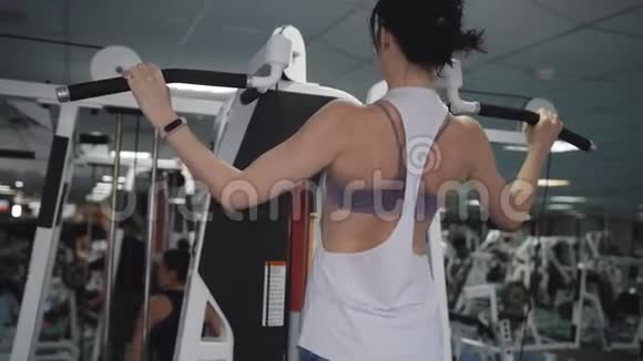 一个女人做练习是正确的背部挺直体育俱乐部的健身教练做拉力赛视频的预览图