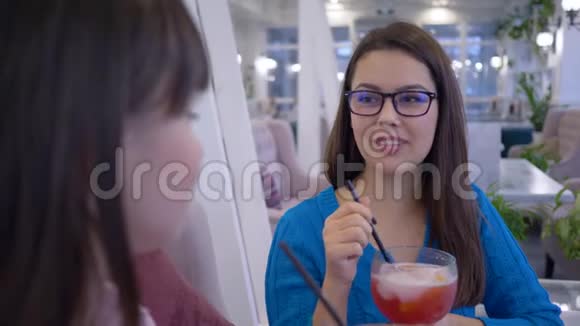 在度假的餐厅里用吸管笑女朋友开心地说和喝果汁视频的预览图