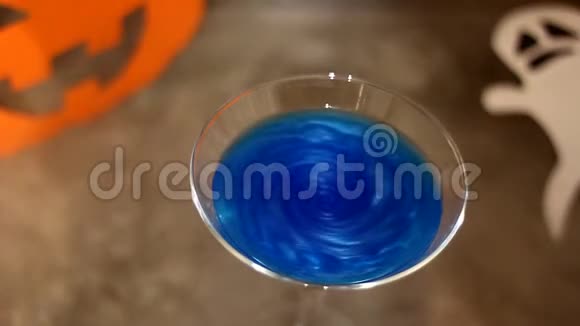 万圣节鸡尾酒这饮料在一杯蓝色的鸡尾酒中搅拌视频的预览图
