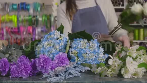 花店老板的手结成一束玫瑰和大丽花视频的预览图
