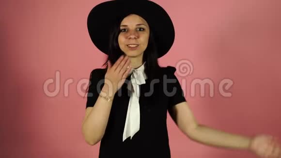 美丽快乐年轻漂亮的女人摆着独立的粉红色墙壁背景吹吻视频的预览图