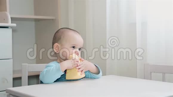 一个饥饿的孩子正坐在孩子们家里的一张白色桌子上吃着自制的奶酪视频的预览图