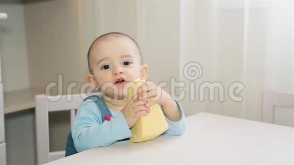 一个饥饿的孩子正坐在孩子们家里的一张白色桌子上吃着自制的奶酪视频的预览图