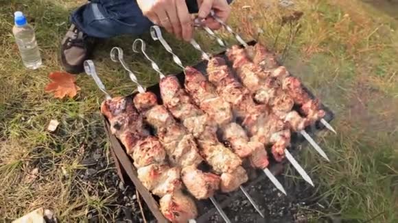 男性将生肉烤在开放式烤架上野餐时烹饪烤烤肉视频的预览图
