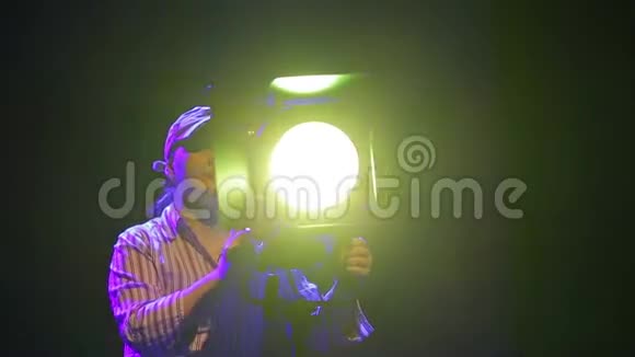舞台上的一位女照明师用一台戏剧放映机制作视频的预览图