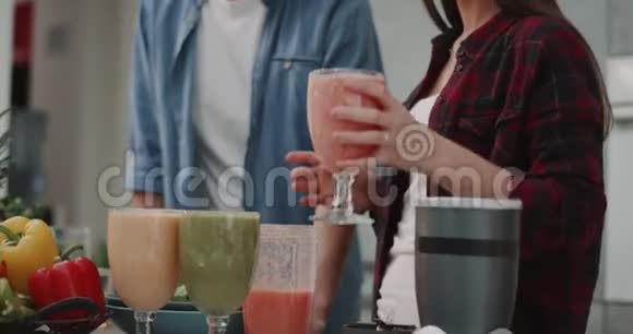 为一对年轻的素食夫妇提供健康早餐他们早上在一个漂亮的现代化的大玻璃杯里喝冰沙视频的预览图
